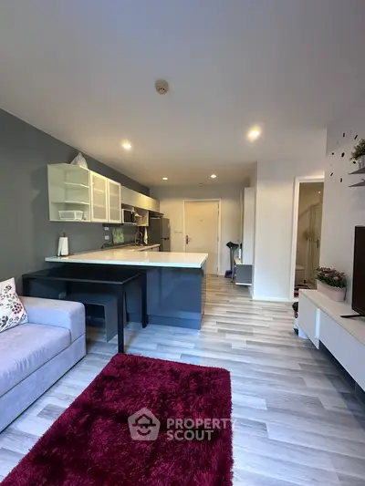 Modern open-plan kitchen and living room with sleek design and cozy atmosphere.