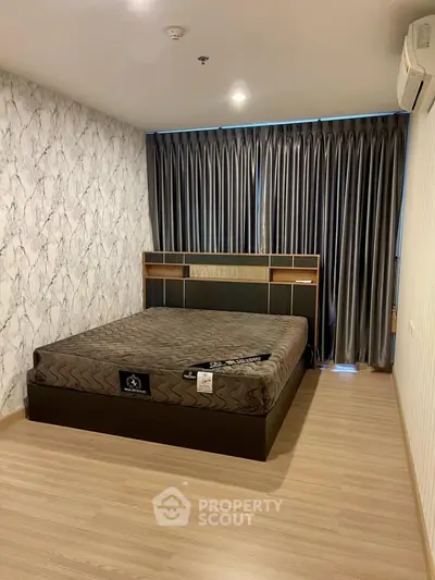 Spacious bedroom with modern decor and large bed, featuring elegant curtains and stylish wallpaper.