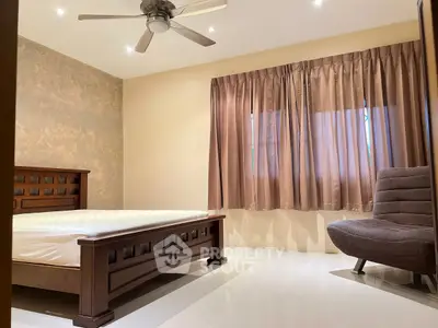 Spacious bedroom with elegant wooden furniture and ceiling fan