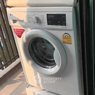 Modern washing machine on a balcony with city view, perfect for urban living convenience.