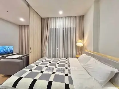Modern bedroom with stylish decor and cozy ambiance, featuring a comfortable bed and elegant lighting.
