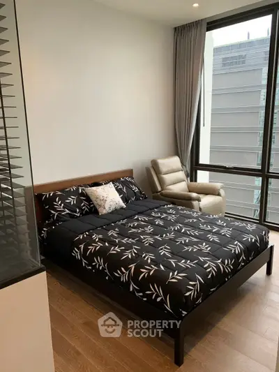 Modern bedroom with stylish decor and large window offering city view