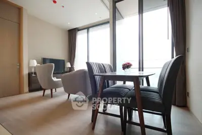 Spacious modern living room with elegant furniture and large windows offering natural light.