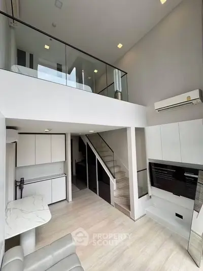 Modern loft apartment with high ceilings and sleek interior design, featuring a mezzanine and open living space.