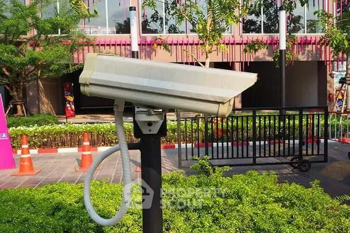 Modern building exterior with security camera and lush greenery