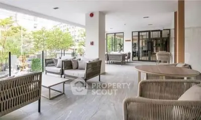 Spacious modern balcony with stylish outdoor seating and lush greenery view.