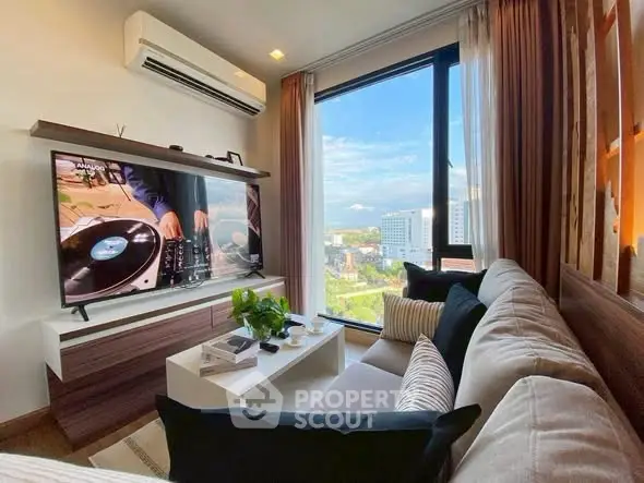 Modern living room with large window and city view, featuring cozy sofa and wall-mounted TV.