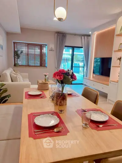Chic living room with elegant dining setup and modern decor, featuring a cozy seating area and large window view.