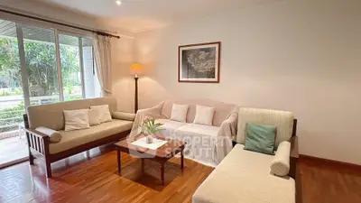 Charming living room with cozy seating and natural light, perfect for relaxation and entertaining.