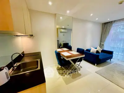 Modern open-plan living room and kitchen with sleek design and natural light.