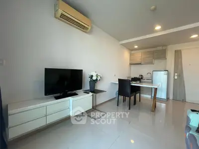 Modern living room with sleek furniture and compact kitchen area, perfect for urban living.