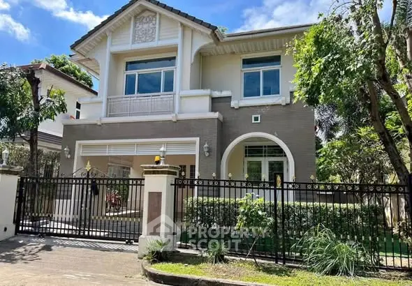 Charming two-story house with elegant facade and lush greenery, perfect for family living.