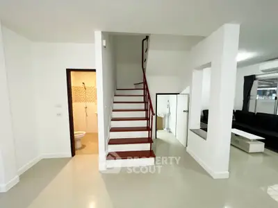 Modern interior with staircase and living area, featuring sleek design and open space.