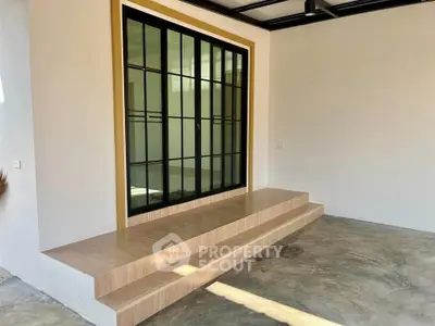 Modern entrance with sleek glass doors and minimalist steps in a contemporary home.