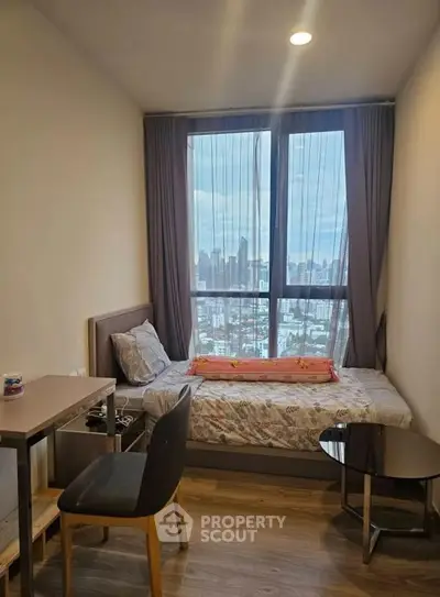 Cozy bedroom with city view, modern furnishings, and ample natural light.