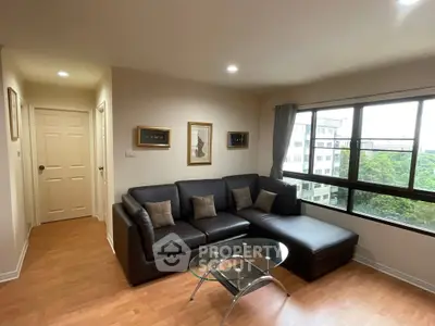 Modern living room with large window and stylish furniture in high-rise apartment.