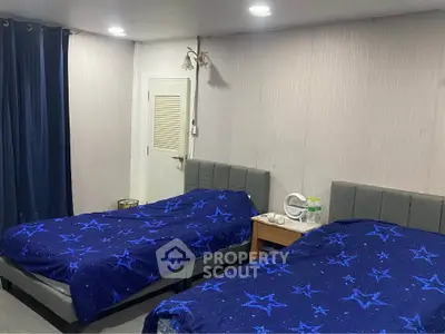 Cozy bedroom with twin beds and starry blue bedding, ideal for restful nights.