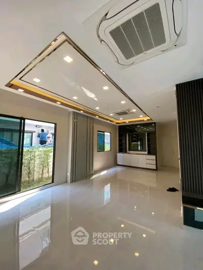Modern living room with sleek ceiling design and large windows for natural light.