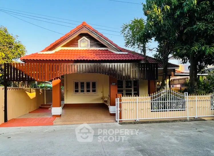 Charming single-story house with red-tiled roof and gated entrance, perfect for family living.
