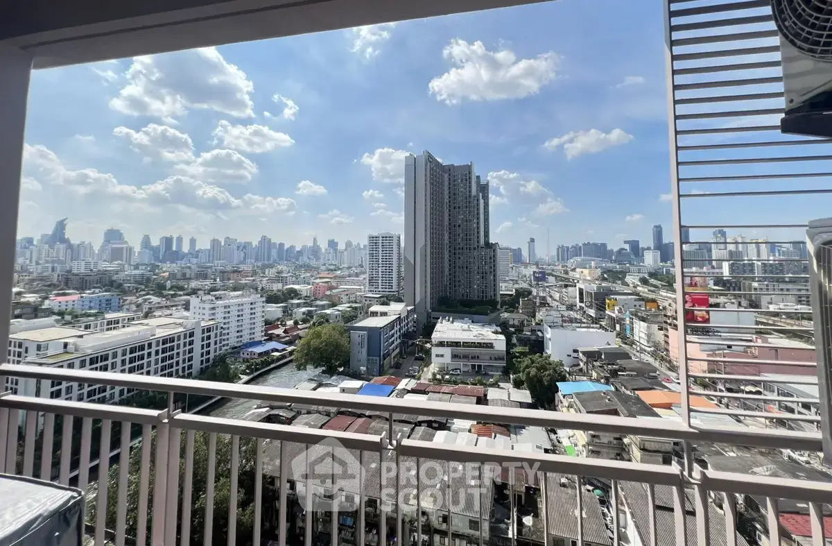 Stunning cityscape view from a high-rise balcony overlooking urban skyline and blue sky.