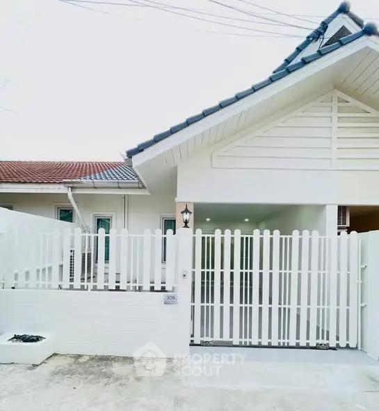 Charming white house with picket fence and inviting entrance