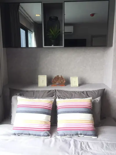 Cozy bedroom with stylish decor and striped pillows, perfect for relaxation.