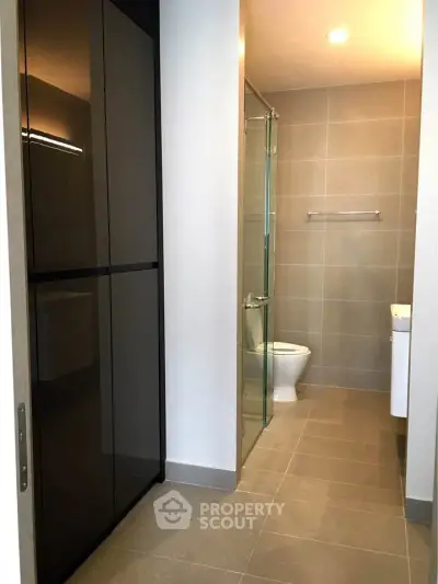 Modern bathroom with sleek design and glass shower enclosure in a contemporary apartment.
