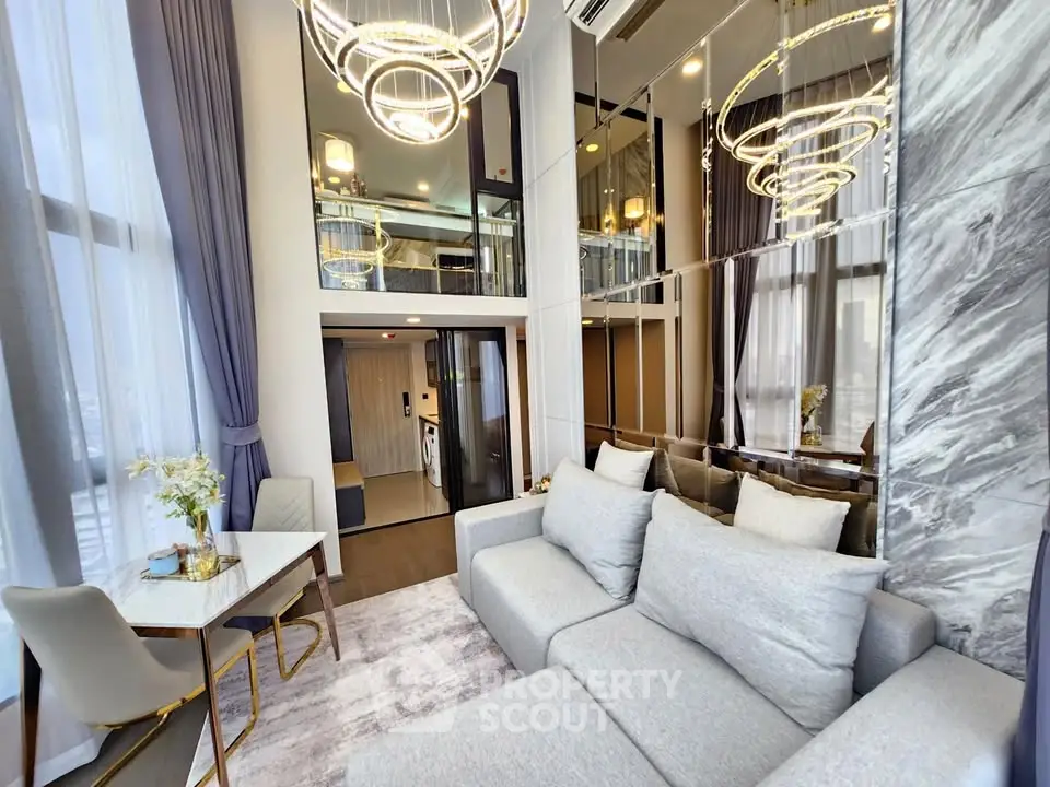 Luxurious modern living room with high ceilings and elegant chandeliers in a stylish apartment.