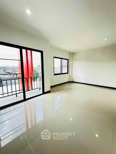 Spacious modern living room with large windows and balcony access