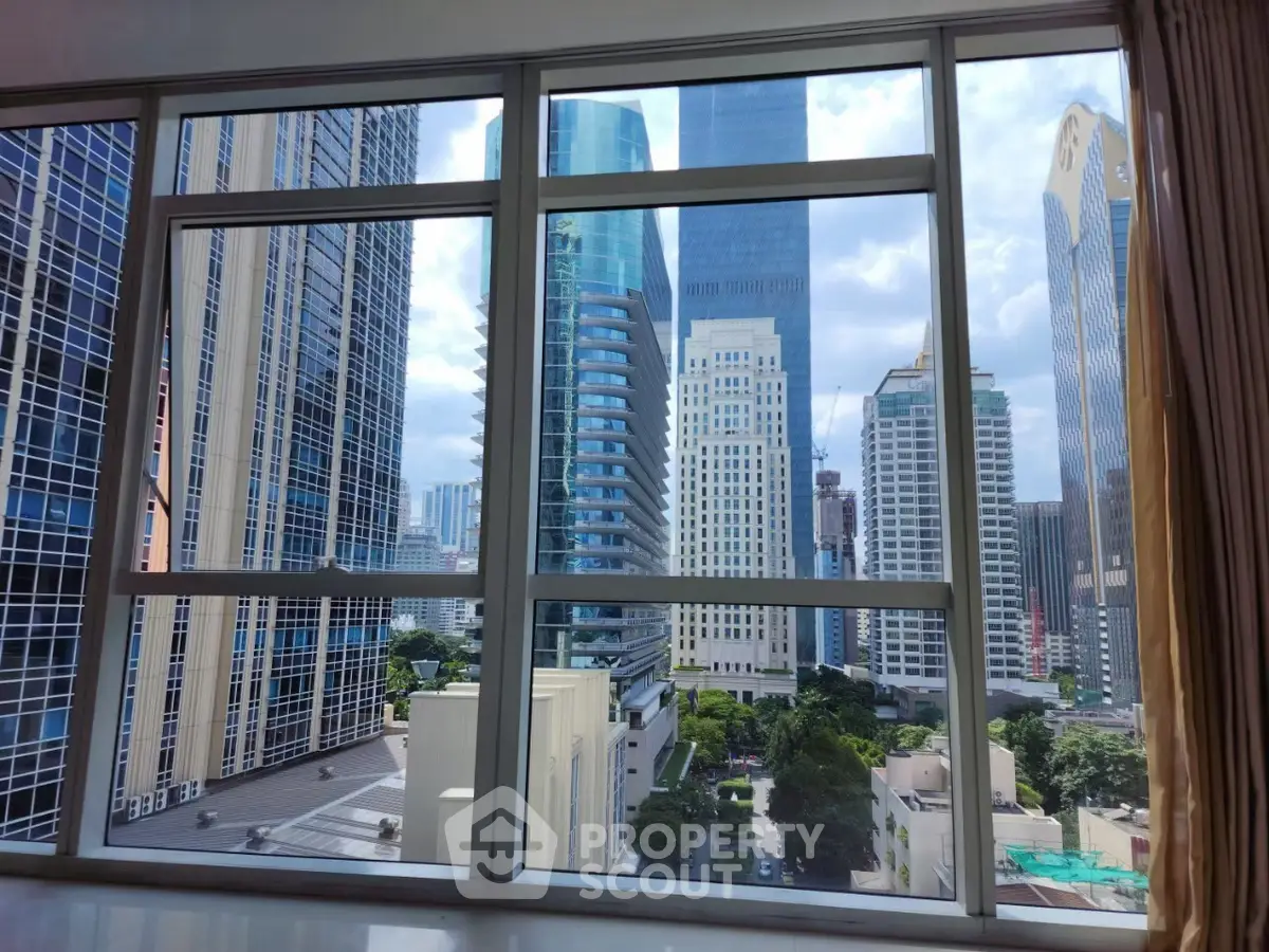 Stunning cityscape view from high-rise apartment window, showcasing modern skyscrapers and urban skyline.