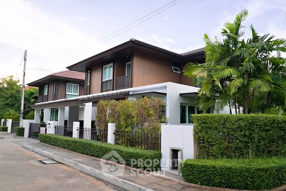 Modern two-story house with lush greenery and stylish exterior design.