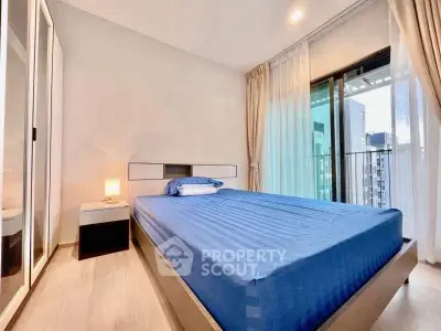 Modern bedroom with blue bedding and balcony view in a stylish apartment.
