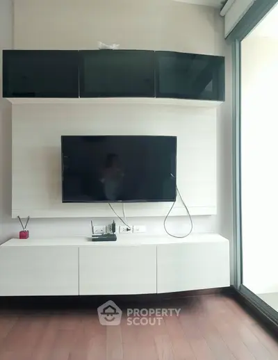 Modern living room with sleek TV setup and elegant wooden flooring.