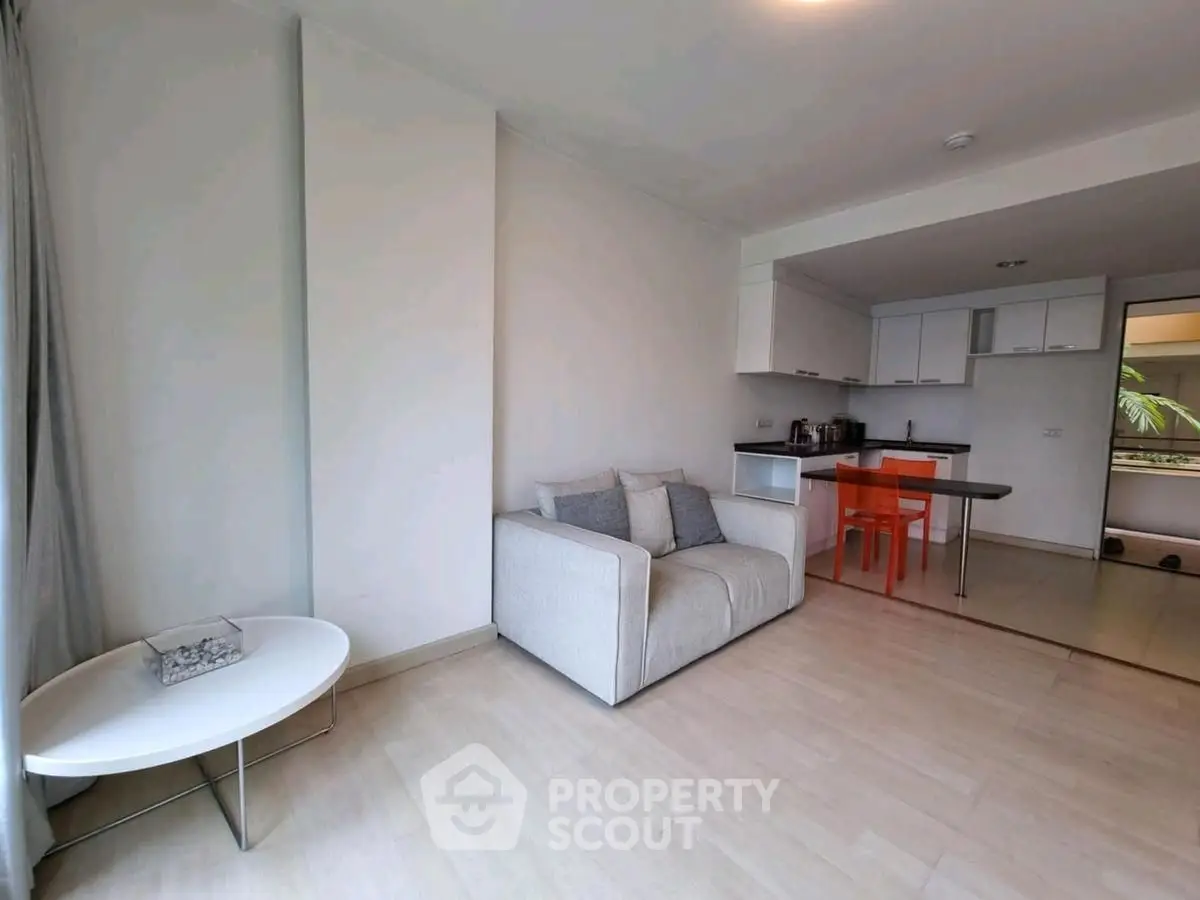 Modern open-plan living room with sleek kitchen and cozy seating area.