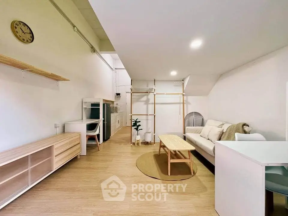 Modern living room with minimalist design and open layout, featuring cozy seating and stylish decor.
