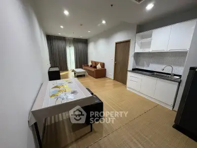 Modern open-plan living room with sleek kitchen and cozy seating area, perfect for urban living.