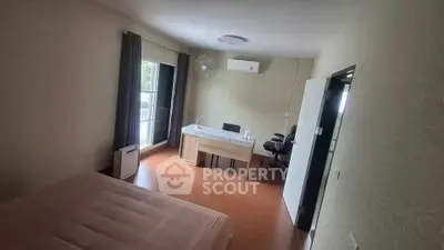 Spacious bedroom with desk and large window in modern apartment