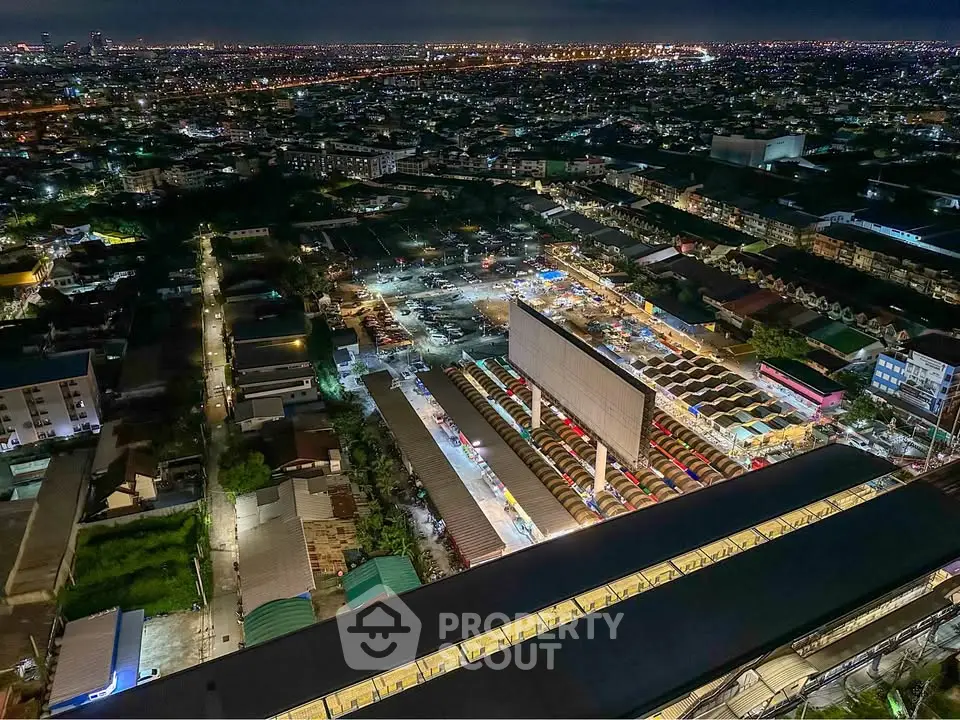 Stunning aerial night view of a vibrant cityscape with illuminated buildings and bustling streets.
