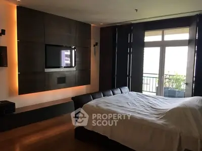Luxurious bedroom with modern design and large windows opening to a balcony.