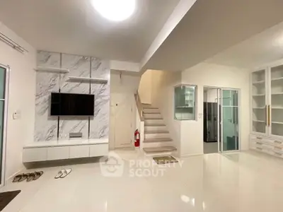 Spacious modern living room with sleek design and elegant staircase
