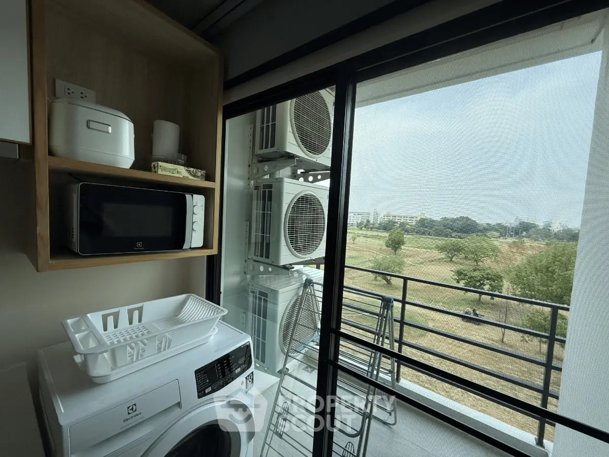 Modern apartment balcony with laundry area and scenic park view