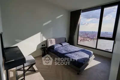 Stunning bedroom with panoramic city and river views, modern furnishings, and ample natural light.