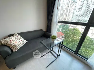 Cozy living room with city view, featuring a stylish sofa and glass table.