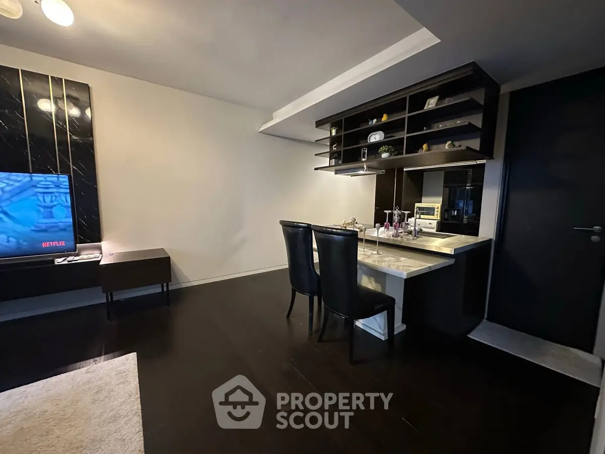 Modern living room with sleek dark flooring and stylish dining area