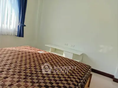 Cozy bedroom with natural light and simple furnishings, perfect for relaxation.