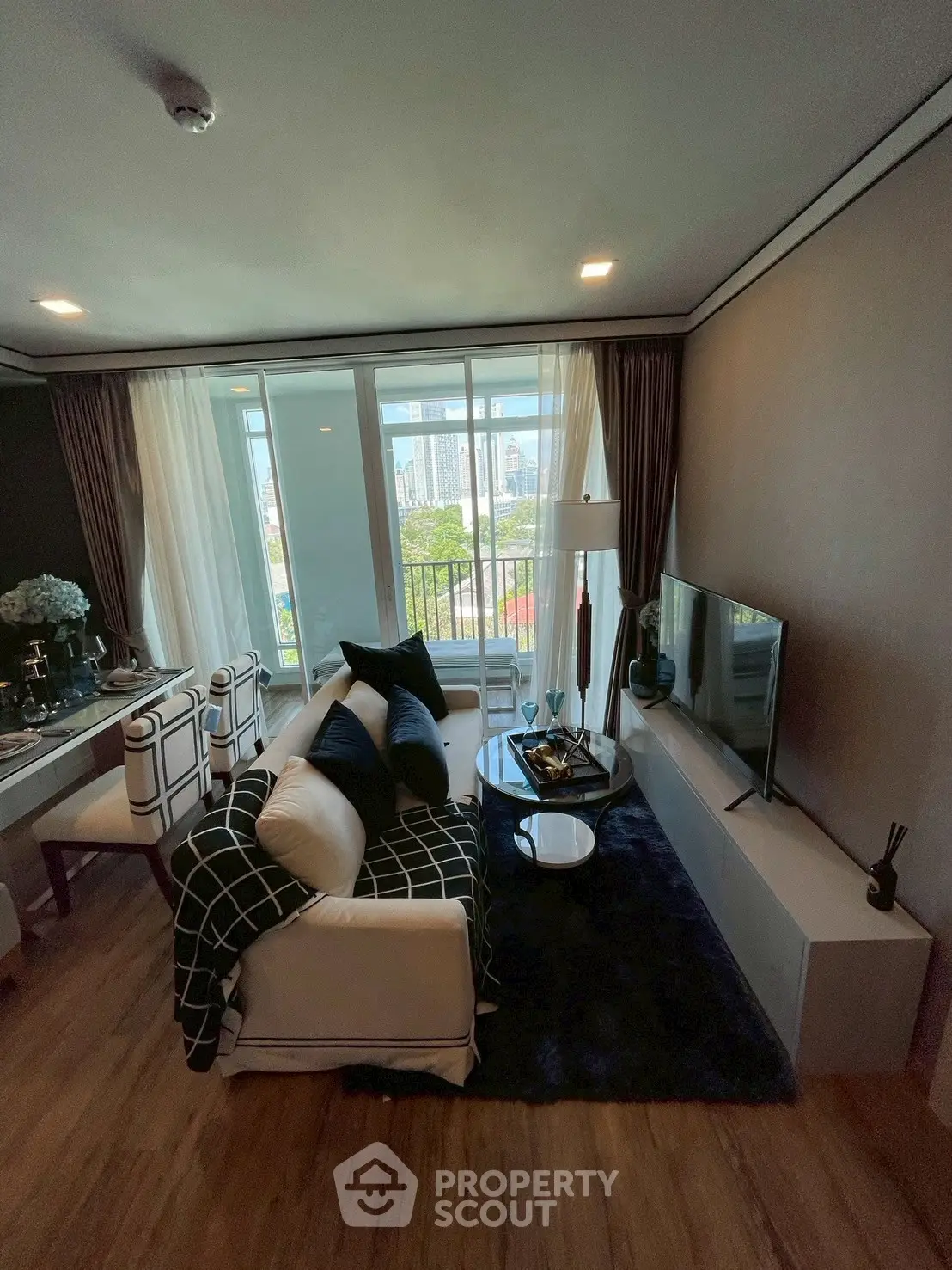 Stylish living room with modern decor and city view from large windows.