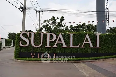 Entrance sign of Supalai Ville with lush greenery and modern design.