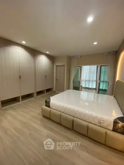 Spacious modern bedroom with elegant built-in wardrobes and large windows for natural light.