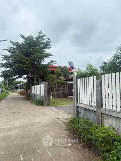 Charming suburban property with lush greenery and a secure fence, perfect for privacy and tranquility.