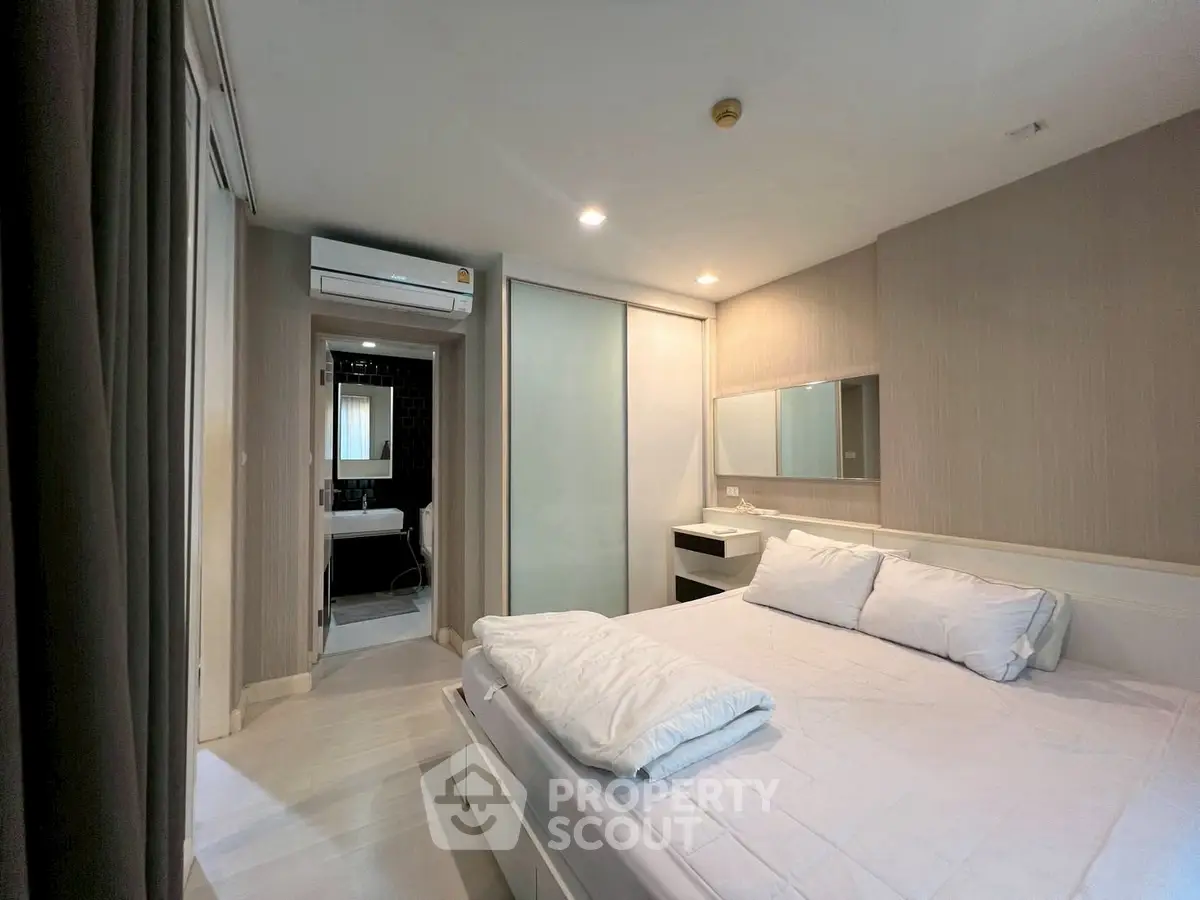 Modern bedroom with ensuite bathroom and sleek design in a stylish apartment.
